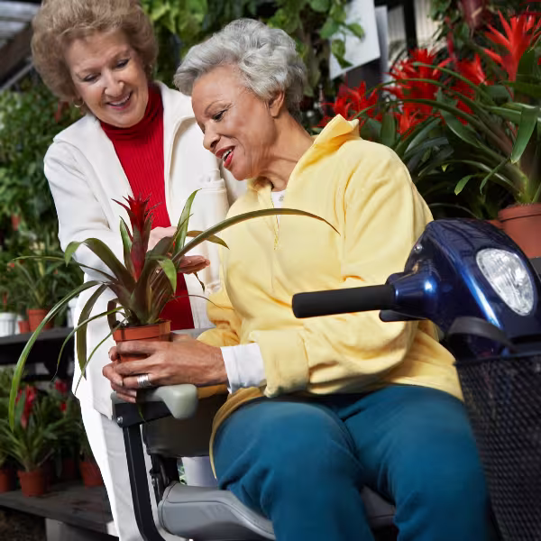 Woman helping another woman in a wheelchair