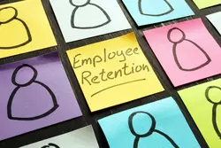 Sticky notes on a desk labeled "employee retention"